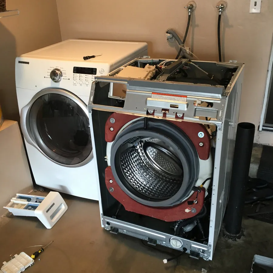 Appliance Techie technician repairing a washer pulled apart at a home in Orange County